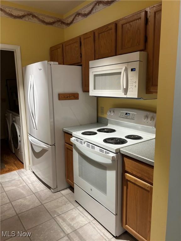 kitchen with white appliances and washer / clothes dryer