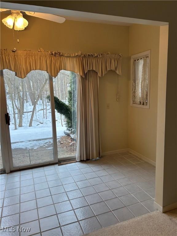 tiled empty room with ceiling fan