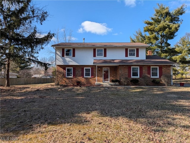 traditional-style house with brick siding and fence