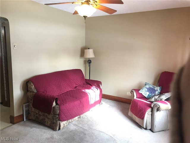 living area featuring ceiling fan and light colored carpet