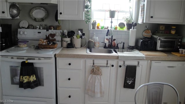 kitchen with white cabinetry, sink, white appliances, and tasteful backsplash