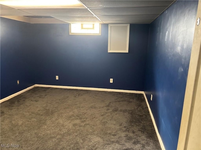 basement with a paneled ceiling and carpet