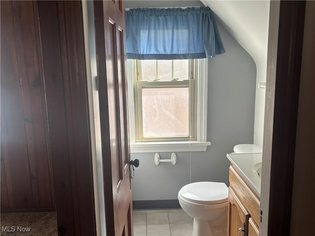 bathroom with lofted ceiling, vanity, toilet, and a wealth of natural light