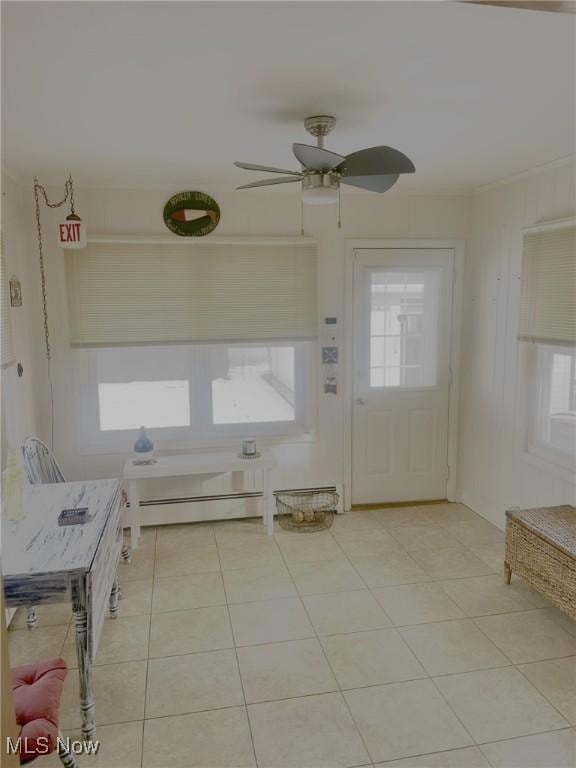 interior space with ceiling fan, a baseboard heating unit, and light tile patterned floors