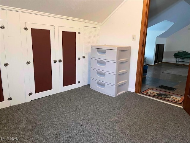 unfurnished bedroom with vaulted ceiling, ornamental molding, a closet, and carpet flooring