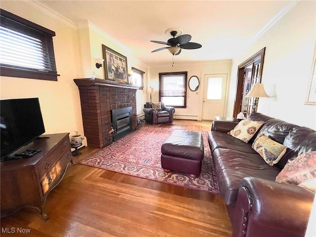 living room featuring a baseboard radiator, a brick fireplace, ceiling fan, and crown molding