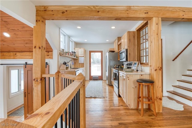 kitchen with stainless steel appliances, sink, light wood-type flooring, and decorative backsplash