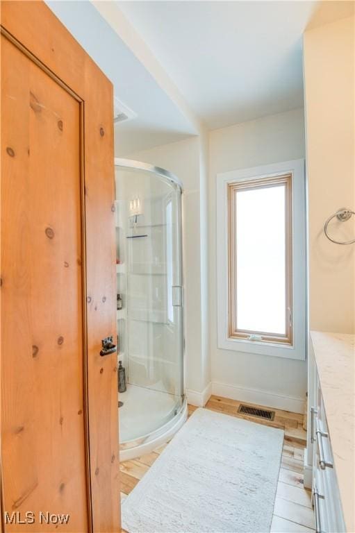 bathroom with vanity and a shower with door