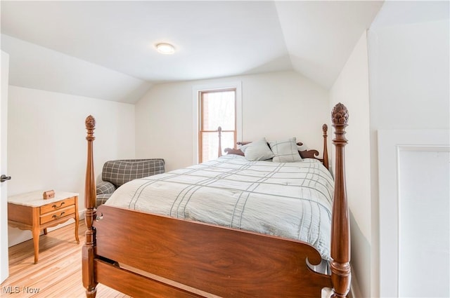 bedroom with vaulted ceiling and hardwood / wood-style floors