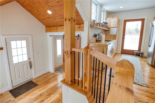 foyer entrance with sink, wood ceiling, vaulted ceiling, and light wood-type flooring