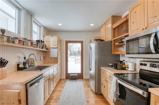 kitchen featuring stainless steel appliances, light hardwood / wood-style floors, sink, and light brown cabinets