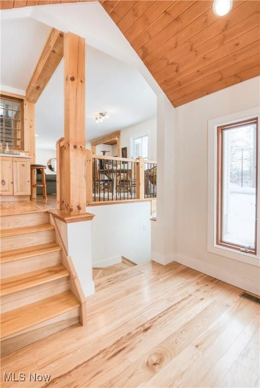 interior space featuring lofted ceiling, wood-type flooring, wooden ceiling, and a wealth of natural light