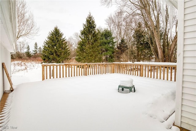 snow covered patio featuring a wooden deck