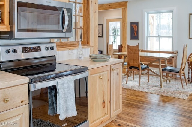 kitchen featuring stainless steel appliances, light brown cabinetry, and light hardwood / wood-style floors