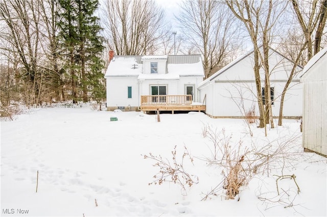 snow covered house featuring a deck