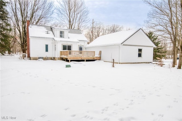 snow covered back of property featuring a wooden deck