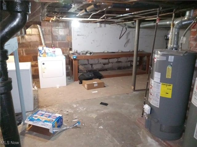 unfinished below grade area featuring water heater, a workshop area, and washing machine and dryer