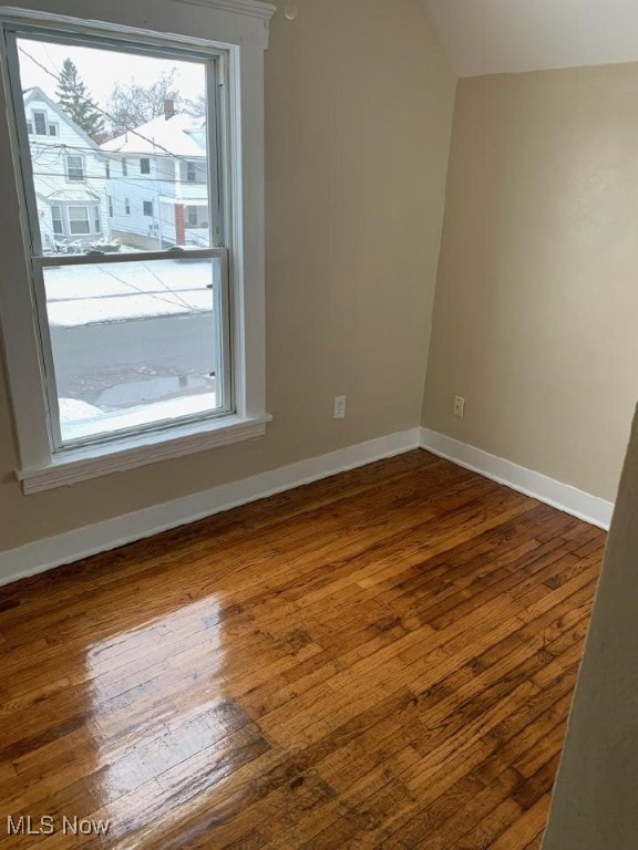 empty room featuring dark wood-type flooring and baseboards