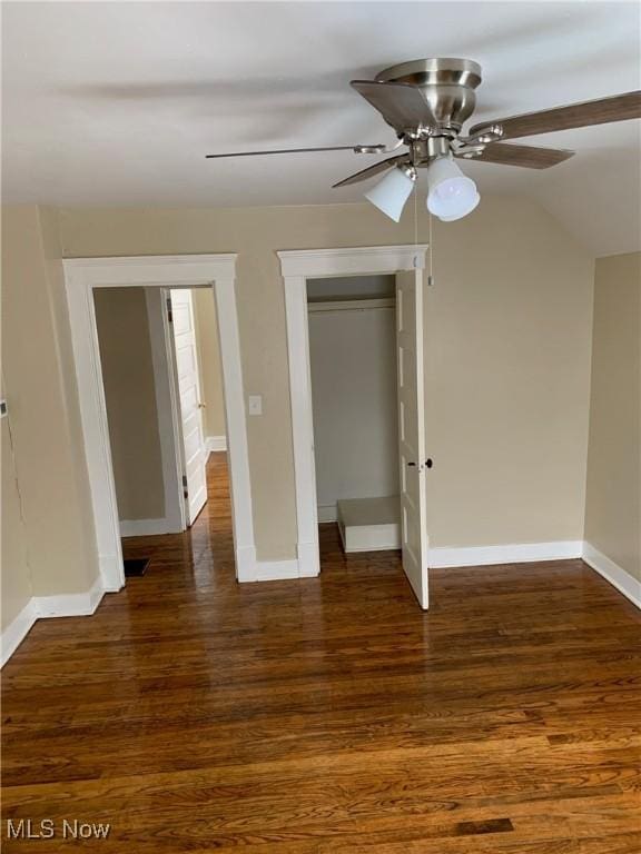 unfurnished bedroom featuring a closet, baseboards, and dark wood-style flooring