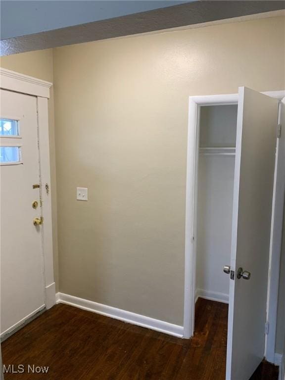 entryway featuring baseboards and dark wood-style flooring