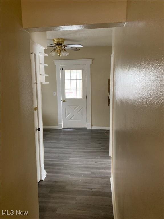 hall with baseboards and dark wood-style flooring