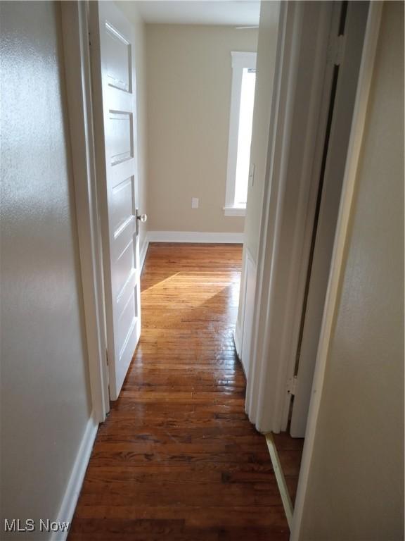 hall featuring dark wood-style floors and baseboards