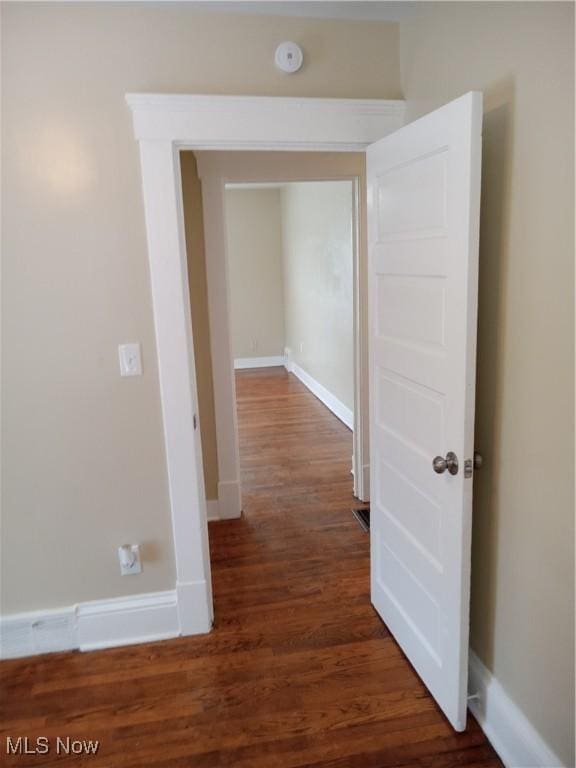 hall with baseboards and dark wood finished floors