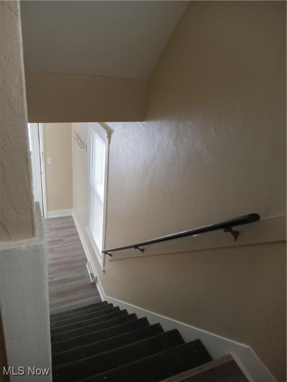 stairs featuring wood finished floors and baseboards