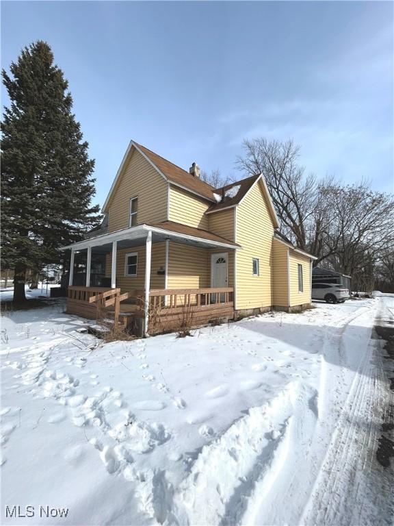 snow covered property featuring a porch