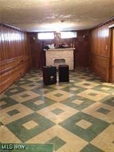 basement featuring dark carpet and wooden walls