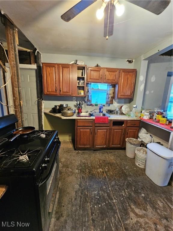 kitchen with black range with gas cooktop, sink, dark wood-type flooring, and ceiling fan