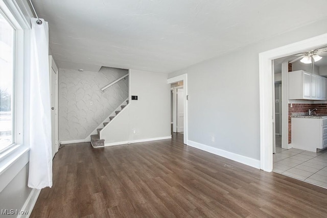 unfurnished living room featuring sink and hardwood / wood-style floors