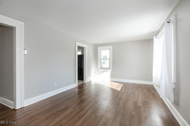 unfurnished room featuring dark wood-type flooring