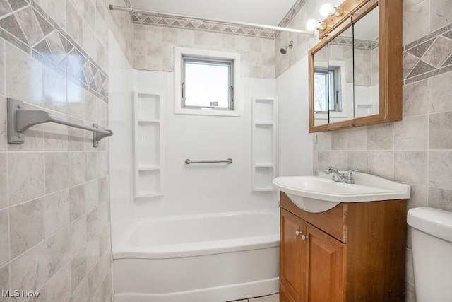 full bathroom featuring vanity, toilet, tile walls, and plenty of natural light