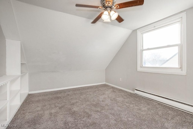 additional living space with baseboard heating, ceiling fan, carpet flooring, and vaulted ceiling