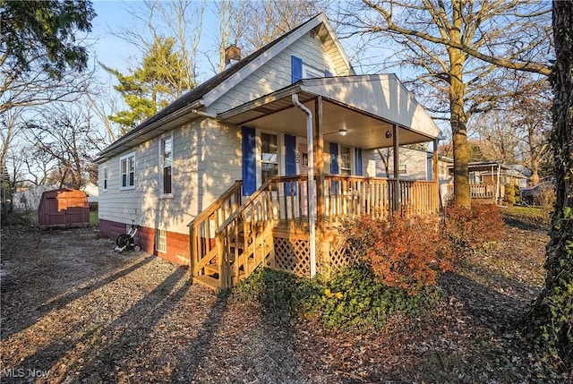 view of front of home with a shed and a porch