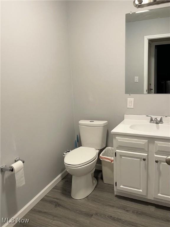 bathroom featuring vanity, wood-type flooring, and toilet