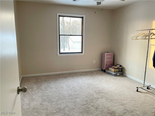 carpeted spare room featuring ceiling fan