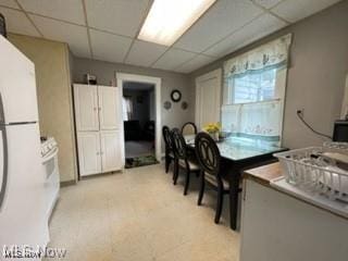 kitchen featuring white refrigerator and a drop ceiling