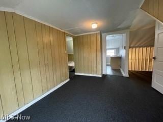 additional living space featuring wood walls