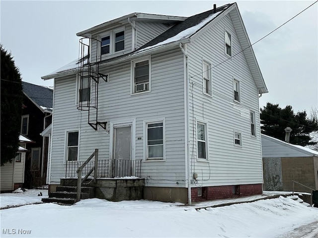 view of snow covered back of property