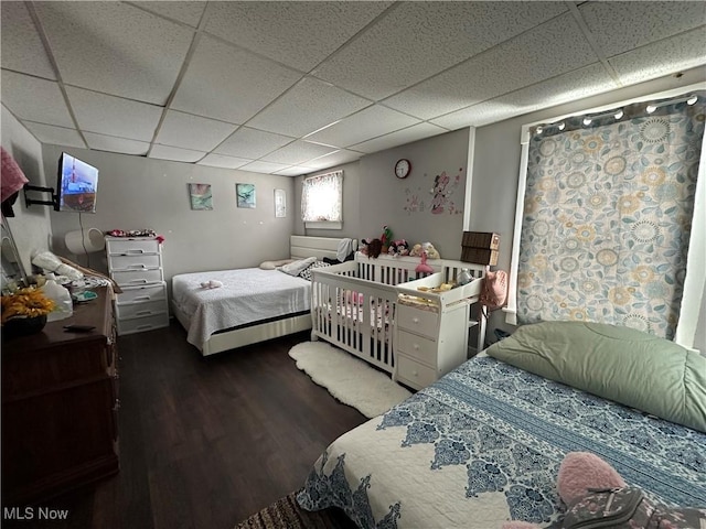 bedroom featuring dark hardwood / wood-style flooring and a drop ceiling