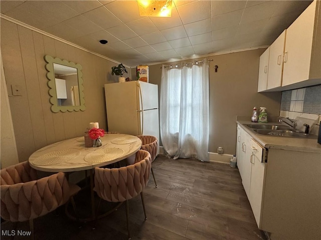 dining room featuring ornamental molding, dark wood-type flooring, and sink