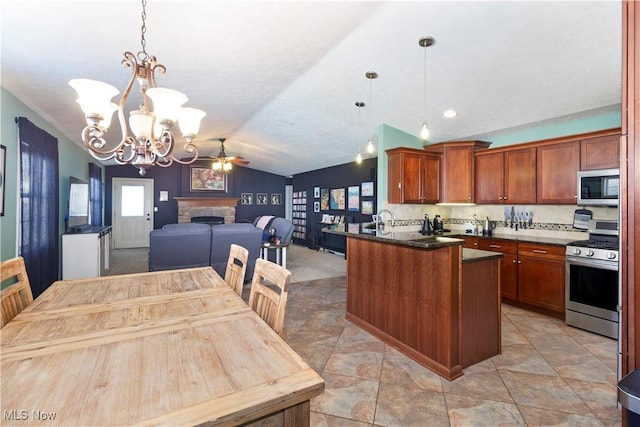 kitchen featuring appliances with stainless steel finishes, lofted ceiling, backsplash, hanging light fixtures, and kitchen peninsula