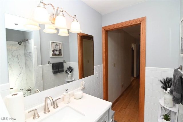 bathroom with vanity, tile walls, and walk in shower