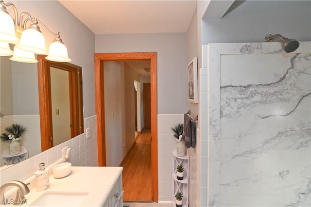 bathroom featuring vanity, tile walls, and a shower