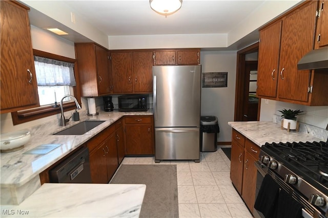 kitchen featuring wall chimney range hood, sink, and black appliances