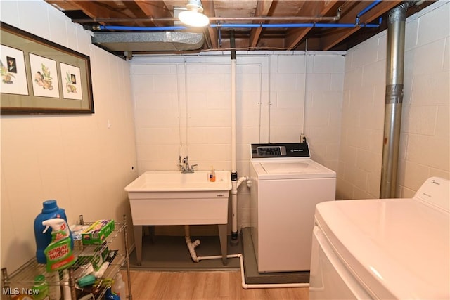 washroom with sink, washer and clothes dryer, and light wood-type flooring