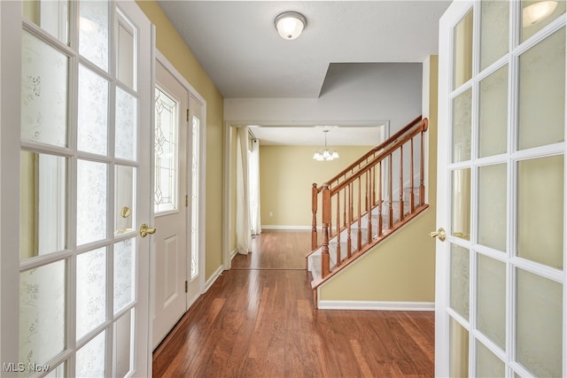 foyer with dark wood-type flooring and a notable chandelier