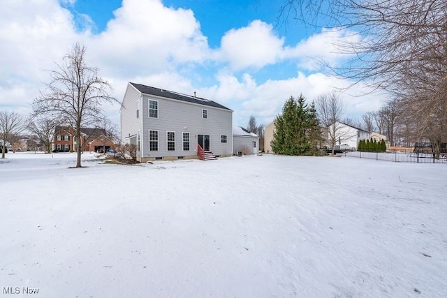 view of snow covered rear of property